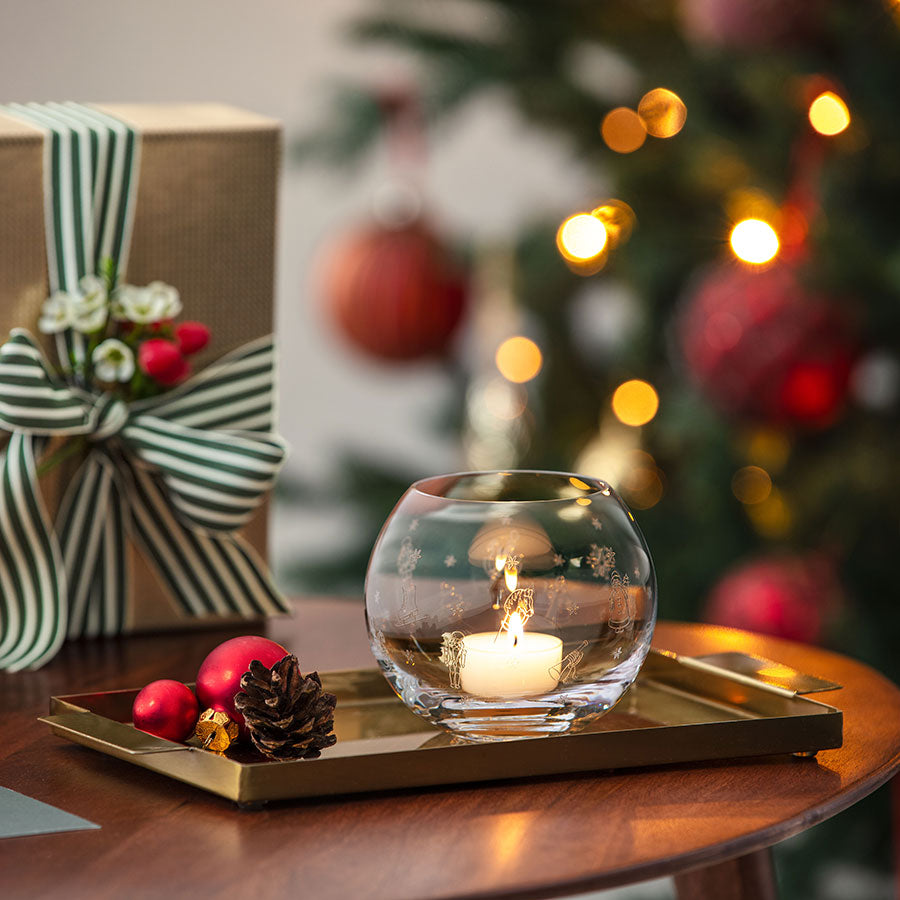 Villeroy & Boch Toys Delight telysholder i bruk, plassert på et pyntet brett med gaver og julepynt, som skaper en koselig atmosfære.