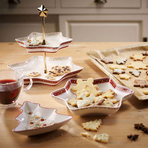 Villeroy & Boch Winter Bakery Delight etasjefat i bruk, fylt med julekaker og småkaker, omgitt av julepynt og en kopp te på kjøkkenbordet. Ideelt for festlig servering.