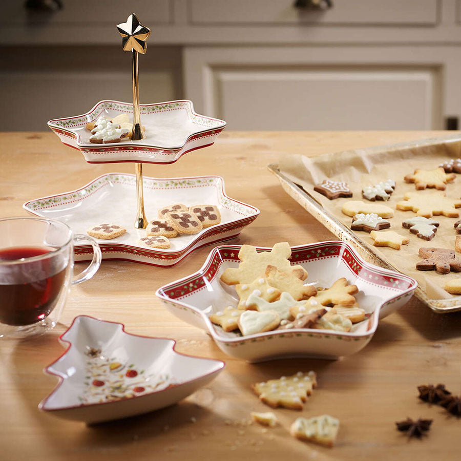 Villeroy & Boch Winter Bakery Delight etasjefat i bruk, fylt med julekaker og småkaker, omgitt av julepynt og en kopp te på kjøkkenbordet. Ideelt for festlig servering.