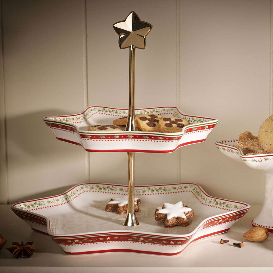 Villeroy & Boch Winter Bakery Delight etasjefat med stjerneform, fylt med delikate julekaker, sett i et koselig julemiljø. Perfekt for elegant presentasjon av julegodt.