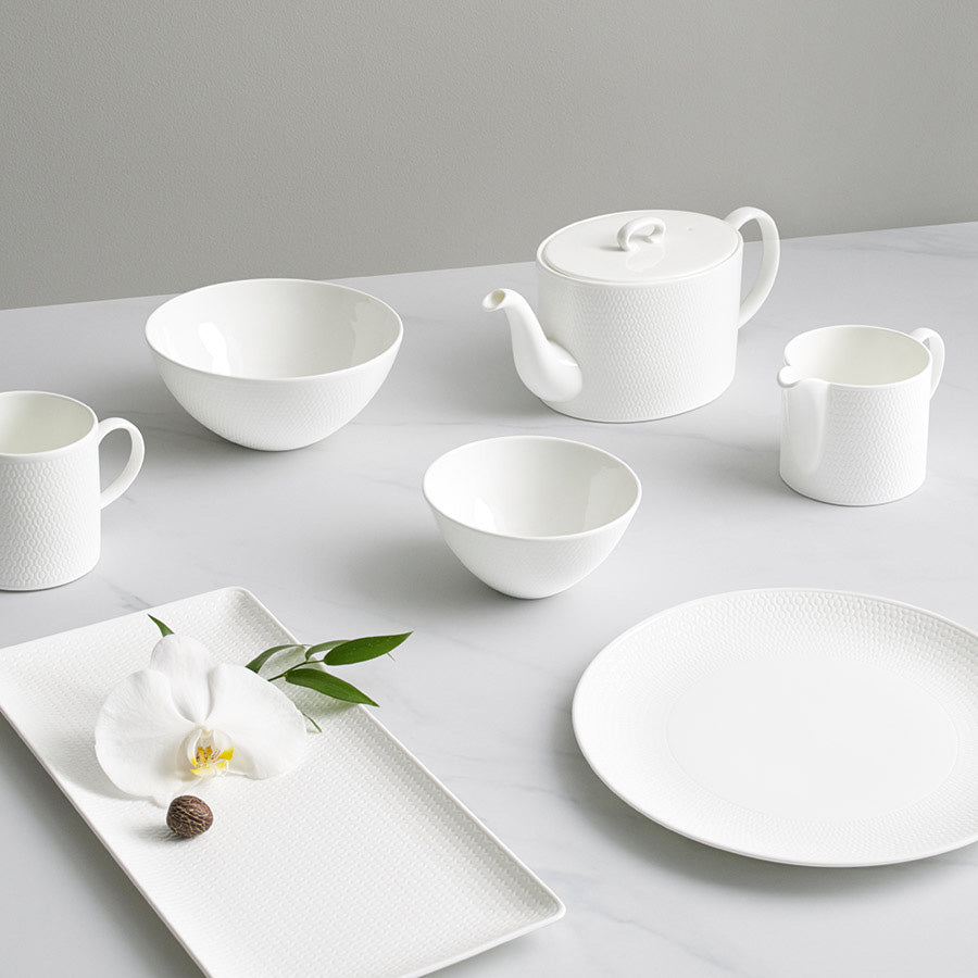Samling av hvite tallerkener og skåler fra Wedgwood Gio-kolleksjonen, inkludert en elegant 16 cm skål, ideell for moderne borddekking.