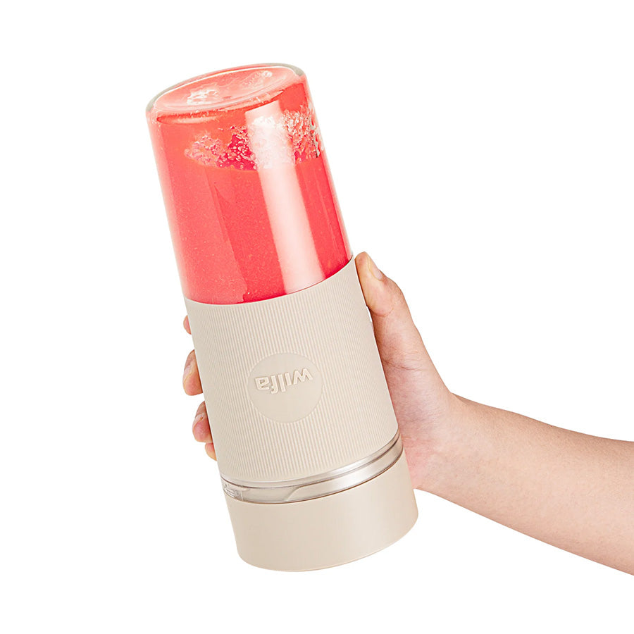 Person som holder Wilfa bærbar blender med smoothie, perfekt for aktive livsstiler.