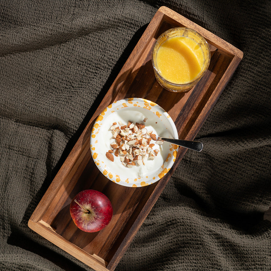 Oversiktsbilde av Zassenhaus serveringsbrett med yoghurt, appelsinjuice og et rødt eple, fremhever brettets elegante design.