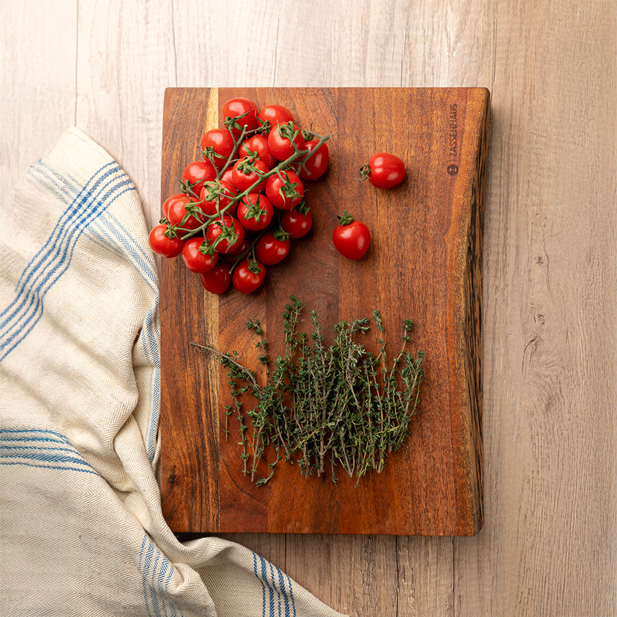 Zassenhaus skjærefjøl i akasietre med ferske tomater og timian, ideell for prepping av råvarer og servering.